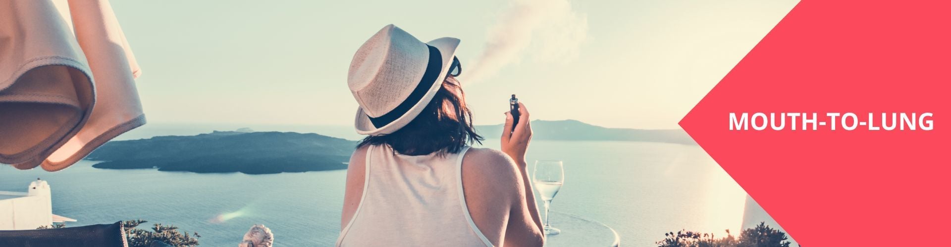 Woman with a hat holding a vape and looking across the sea. Buy Mouth-to-Lung Vape Pods today on Haypp UK.