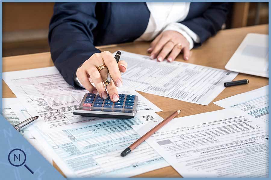 A person using a calculator among papers - Haypp UK